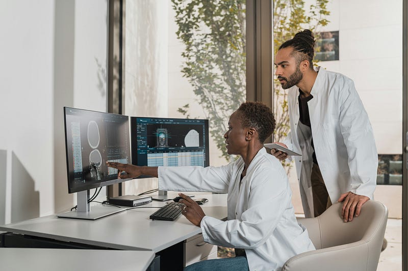 Behavior analyst using ABA software to explain scan data while collaborating with a colleague.