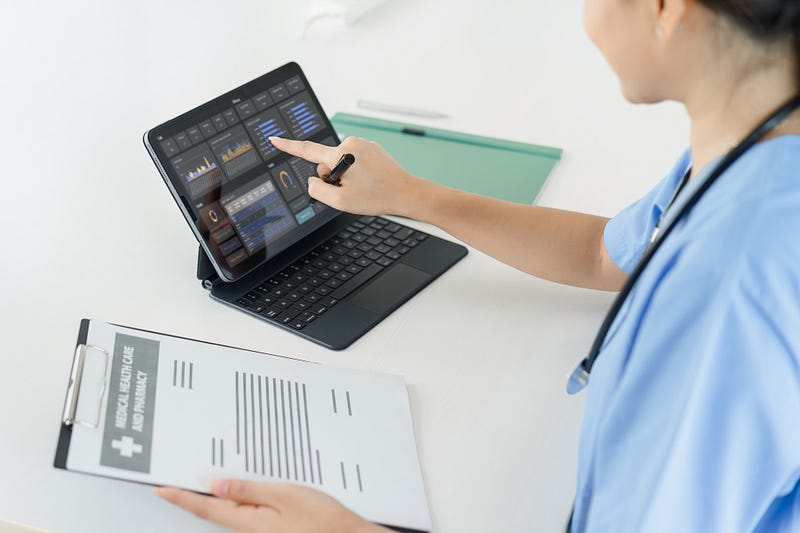 Healthcare administrator using ABA management software on a tablet to review documentation and performance dashboards.