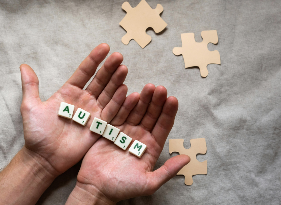 Hands holding autism letter tiles with puzzle pieces, symbolizing teaching social skills autism