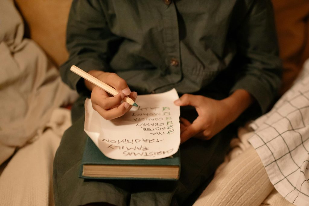 Child writing a family checklist as part of parent training in ABA routines