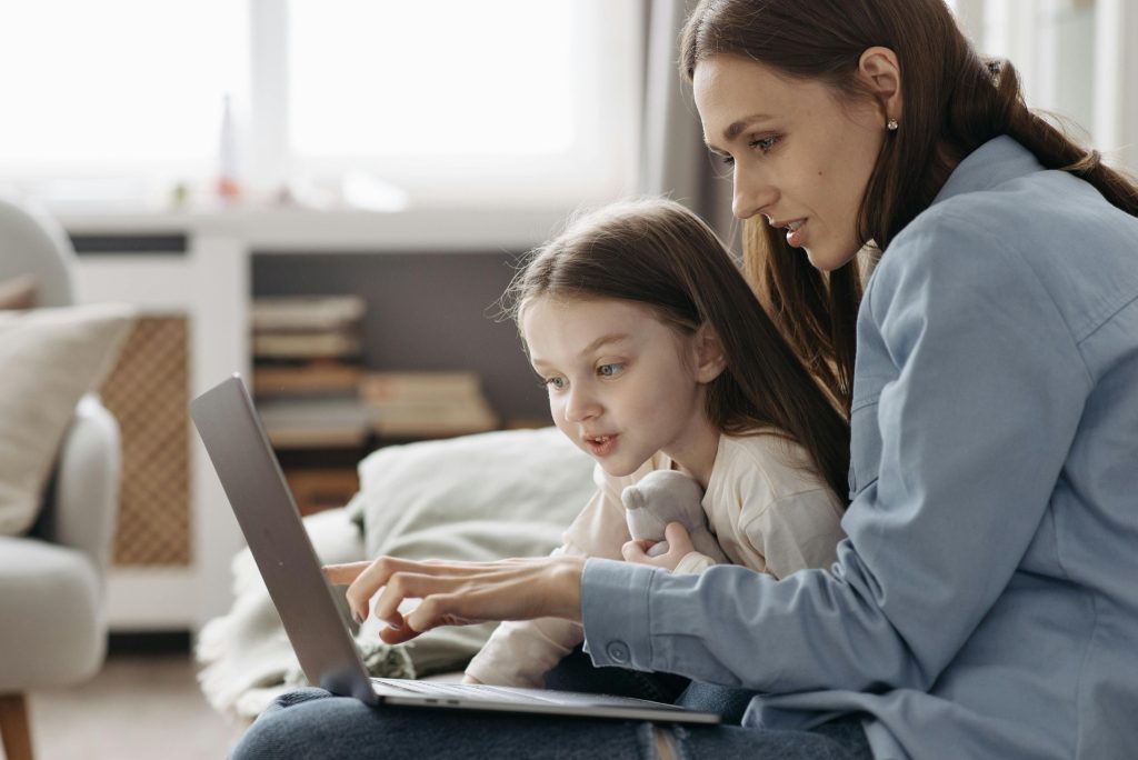Mother guiding child on laptop as part of Autism Advocacy in Public Spaces