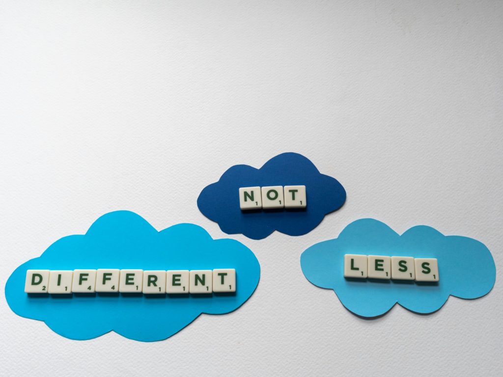 Puzzle pieces spelling ‘Different Not Less,’ symbolizing acceptance and support as children with autism handle school challenges