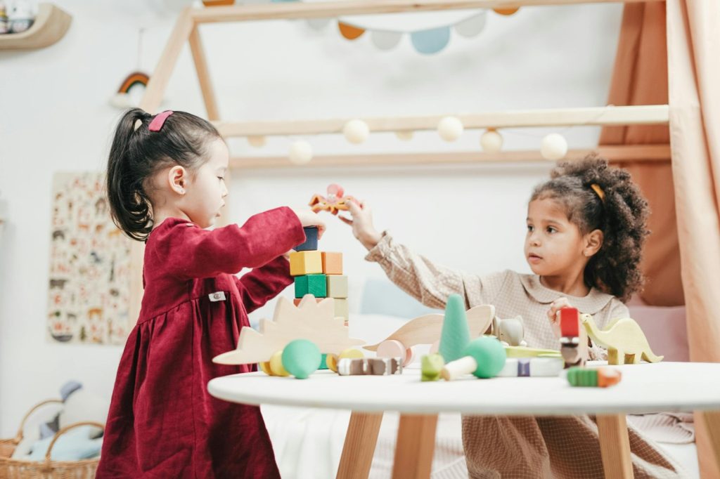 Children engaging in autism and play activities with colorful blocks during a learning session.