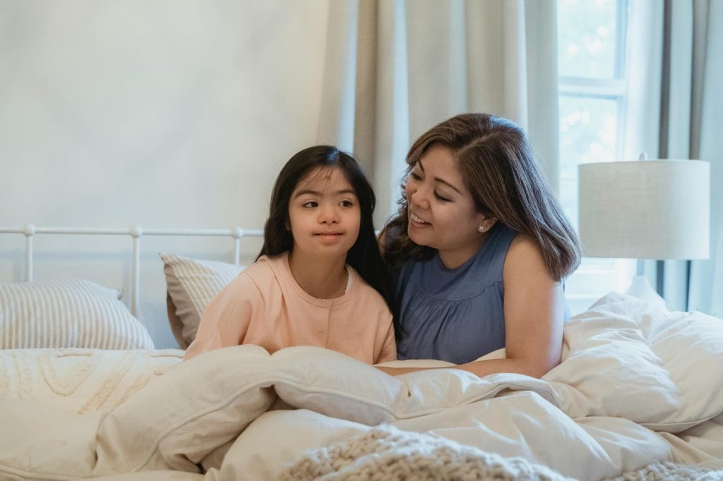Mother supporting child during autism & routine changes at bedtime to build comfort and predictability.